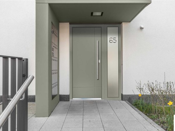 Sage green aluminium entrance door with a full-height bar handle and a glazed side screen
